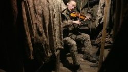 Un soldato impegnato nel conflitto in Ucraina suona il violino