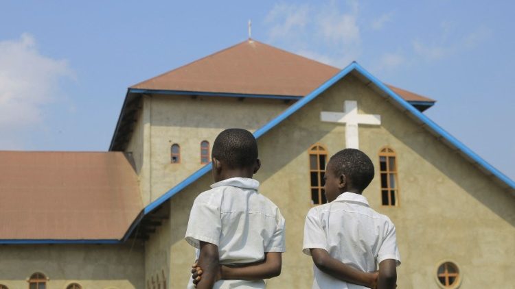 Crianças diante de igreja católica em Benin. após explosão durante cerimônia da Confirmação. (Sebastien Kitsa Musayi) 