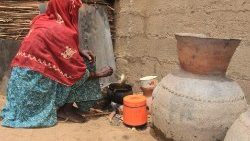 Archivbild: Eine Binnenvertriebene in Borno kocht in einem Auffanglager eine Mahlzeit