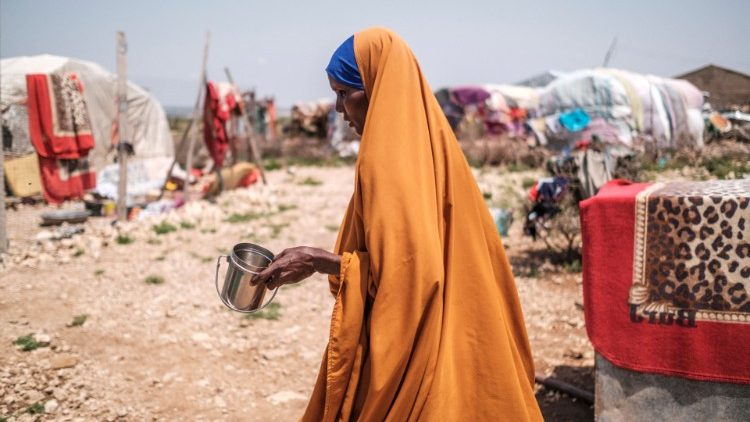 A woman holds a cup for water in an IDP settlement in Somalia