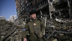 Ukraiński greckokatolicki kapelan wojskowy modlący się wśród gruzów spowodowanych rosyjskim ostrzałem w Kijowie, 21 marca 2022