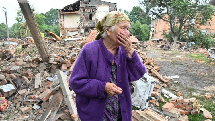 Raisa Kuval, 82 anos, chora diante de sua casa destruída por ataque russo nas proximidades de Kharkiv. (Photo by AFP/Sergey Bobok)