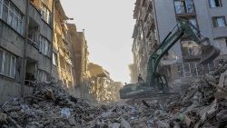 Ein Bagger beseitigt Trümmer inmitten eingestürzter Gebäude in Hatay am 15. Februar 2023, neun Tage nach einem Erdbeben der Stärke 7,8, das Teile der Türkei und Syriens erschütterte.