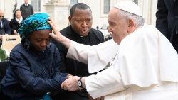 Cette photo prise et distribuée le 8 mars 20223 par les médias du Vatican montre le Pape François bénissant Janada Marcus, une jeune Nigériane victime du groupe islamiste Boko Haram, lors de l'audience générale hebdomadaire du 8 mars 2023 sur la place Saint-Pierre au Vatican. 