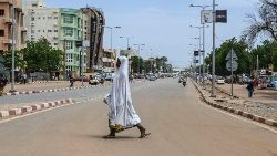 A woman walks across a quiet road in Niamey, Niger on 8 August.