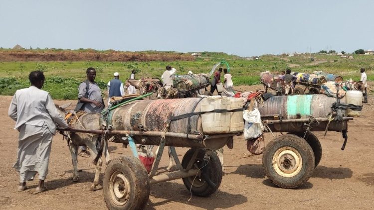 Sudaneses hacen cola para llenar tanques con agua de un pozo en la ciudad de Gadaref.