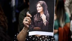 A protester holds a portrait of Mahsa Amini