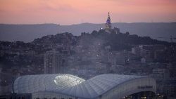 A imagem mostra o estádio, em primeiro plano, e a Basílica de 'Notre-Dame de la Garde' no alto