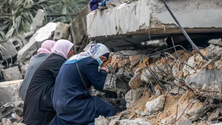 Donne che piangono davanti alle rovine di un edificio a Rafah, nel sud della Striscia di Gaza