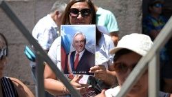 A Chilean woman holds a photo of the late Sebastián Piñera