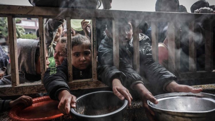 Flüchtlingskinder stehen bei der Essensverteiling in einer Schule in Rafah an