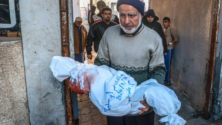 Ein Mann trägt nach einem israelischen Luftangriff in Rafah den Körper eines getöteten Kindes in Richtung Krankenhaus