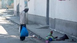 En mann prøver å hjelpe en kvinne som er blitt skutt i foten. Port-au-Prince, Haiti, 9. mars 2024