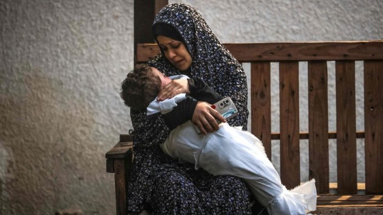 A woman holds her child in Gaza