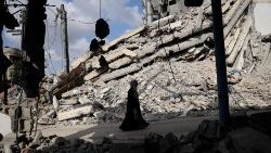   Një grua palestineze ecën mes rrënojave të ndërtesave të shkatërruara në Rafah, në Rripin jugor të Gazës
