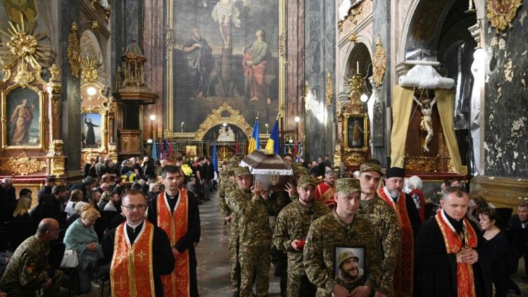  Soldados ucranianos carregam os caixões de militares ucranianos durante um funeral na Igreja dos Santos Pedro e Paulo Garrison em Lviv, em 2 de maio de 2024. 