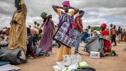 Uma mulher que foi deslocada de sua casa devido a fortes enchentes ajusta o lenço na cabeça enquanto recebe alguns itens entregues pela UNICEF e pela Cruz Vermelha do Quênia em um campo para deslocados em Garissa, em 8 de maio de 2024. (Photo by Luis Tato/AFP)
