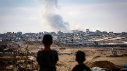Unos niños observan el humo que se desprende durante los ataques israelíes al este de Rafah, en el sur de la Franja de Gaza, el 13 de mayo de 2024 (AFP)