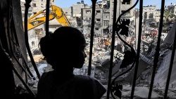 Eine junge Frau blickt im Gaza-Streifen auf die Trümmer eines getroffenen Gebäudes