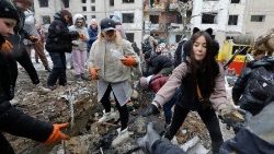 Voluntários limpam os destroços de um canteiro de obras danificado um dia após os ataques russos em Kiev (Ansa)