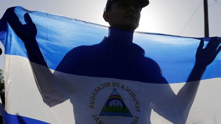 Muškarac drži nacionalnu zastavu tijekom mise za mir u Nikaragvi u katedrali u Managui