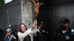 Eine Frau in Nicaragua hält ein Kreuz bei einer Demonstration  für Religionsfreiheit