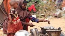 Uma mãe africana cozinha com a filha ao seu lado