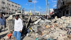 A man walks past wreckage following the explosion in Mogadishu