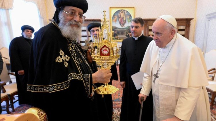 Coptic Orthodox Pope Tawadros II holds up a reliquary of the 21 martyrs