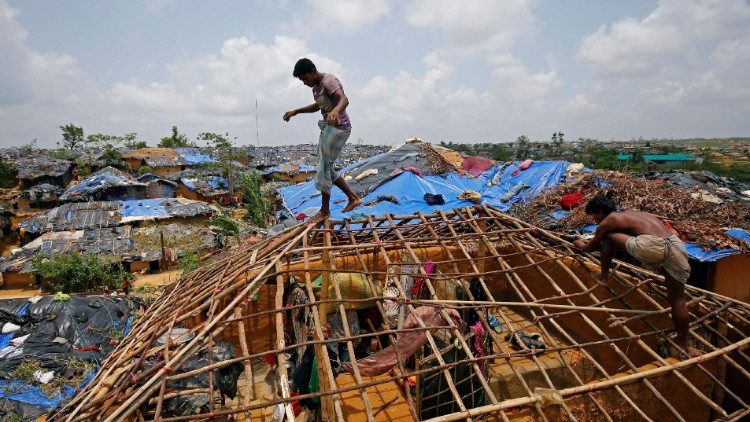 Rohingya refugees rebuilding their homes in their refugee camp after they were destroyed by a cyclone