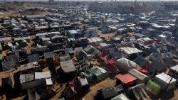 Palestinos deslocados, que fugiram de suas casas devido ao conflito entre Israel e Hamas, abrigam-se num acampamento, em Rafah