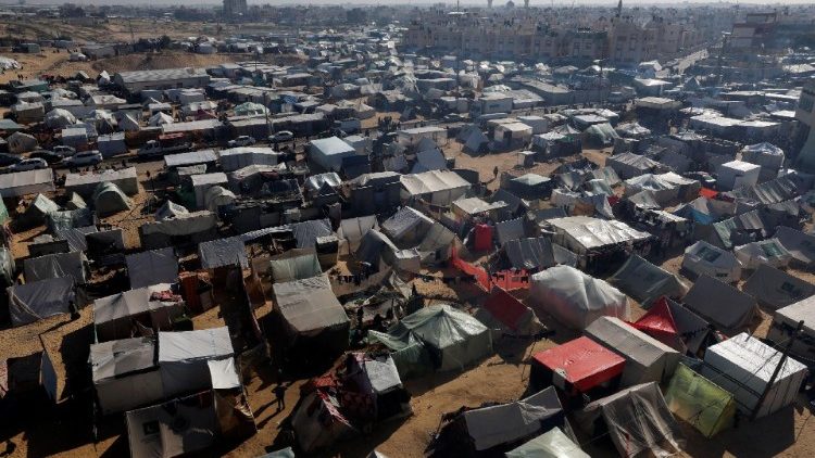 Palestinos deslocados, que fugiram de suas casas devido ao conflito entre Israel e Hamas, abrigam-se num acampamento, em Rafah