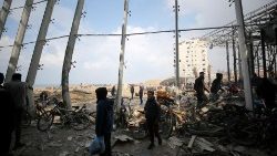 Palestinesi riuniti per caricare sacchi di farina sui camion degli aiuti a Gaza City