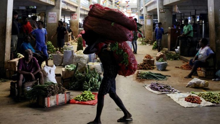 Ein Arbeiter trägt einen Sack mit Gemüse auf einem Markt in Colombo, Sri Lanka