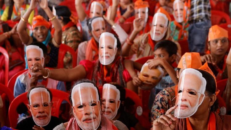 Des soutiens du président Narendra Modi portent des masques à son effigie lors d'un meeting de campagne. 