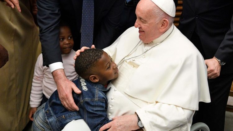 Papa Francisco abraça um menino na audiência aos refugiados que chegaram à Europa através dos corredores humanitários