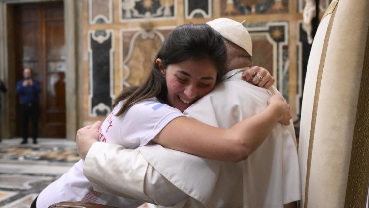 Papst Franziskus umarmt eine Jugendliche 