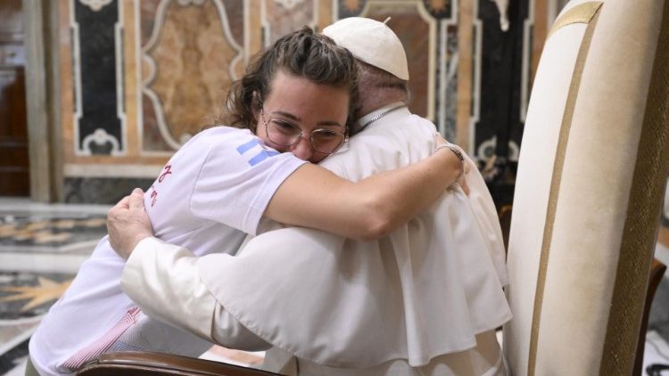 Pope Francis hugs a young lady from Argentina