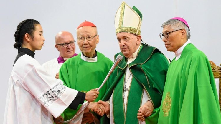 Pope Francis holds the Cardinal's and Cardinal-elect's hands