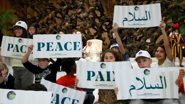 Pope Francis in between children holding up signs with the world "peace" written in various languages