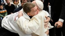 האפיפיור פרנציסקוס מחבק בחור צעיר במהלך קבלת הקהל האחרונה 