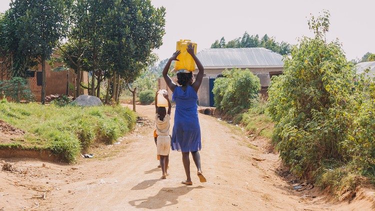 Uganda, una donna con sua figlia fanno rifornimento d'acqua