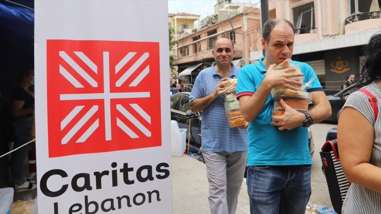 Miembros de Caritas Líbano distribuyen alimentos.