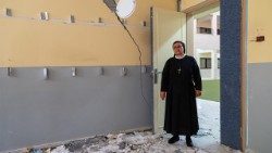 Sister Nabila surveys damage inside the Holy Family parish compound