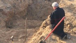 Kard. Konrad Krajewski, wysłannik papieża w Ukrainie, modli się nad masowym grobem w Borodziance, 15 kwietnia 2022 r., Wielki Piątek