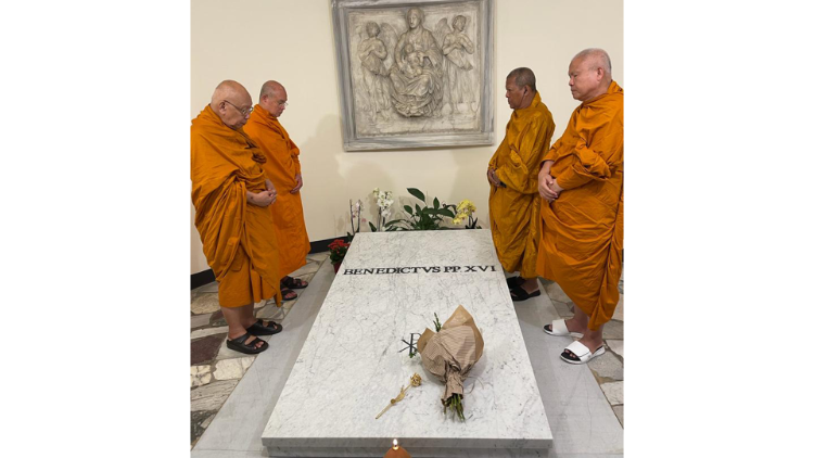 La delegación budista reza frente a la tumba del difunto Papa Benedicto XVI