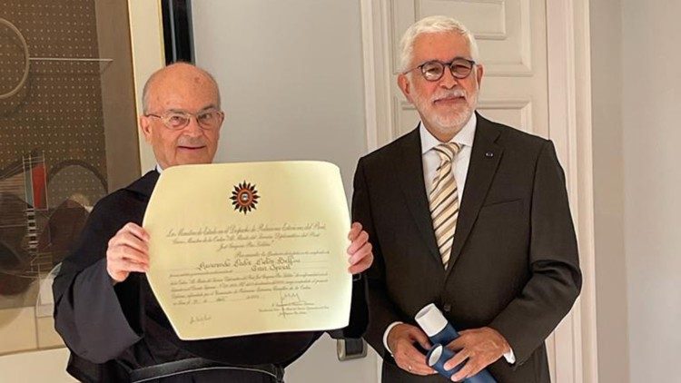 Padre Bellini mostra la pergamena con le motivazioni dell'onorificenza ricevuta dal Governo del Perù
