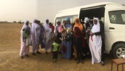 Des parents avec leurs enfants, devant un mini-bus offert par le projet Papal Foundation 