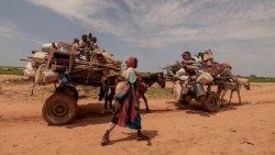Una donna supera il confine tra Sudan e Ciad, nella città di Adré in Ciad