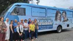 Suor Alessandra e le volontarie del "Micro da Caridade" di fronte al minibus utilizzato anche per la distribuzione di cibo e prodotti per l'igiene personale